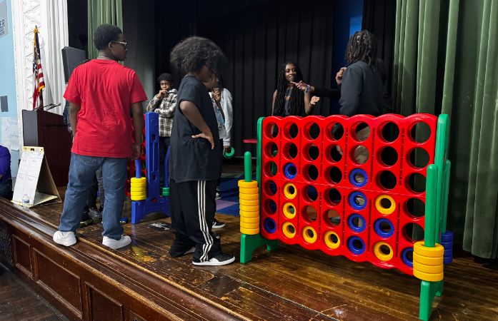  students on stage playing giant connect 4